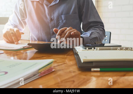 Close up Businessman hand using calculator. Professional investor calculate about cost. Finance managers task. Stock Photo