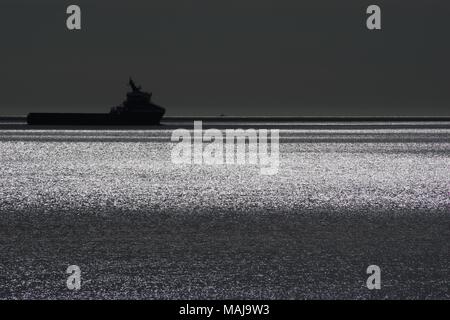 Offshore Support Vessel, Silhouetted on a Sparkling Tranquil North Sea. Aberdeen, Scotland, UK. Stock Photo