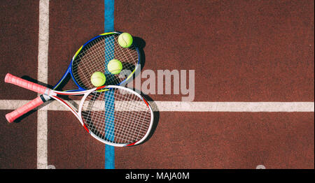 Tennis Balls with Racket in tennis court Stock Photo