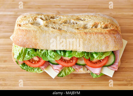 Ciabatta sandwich or club sandwich with ciabatta baguette and various ingredients. ham and cheese baguette with fresh tomatoes and salad. Stock Photo