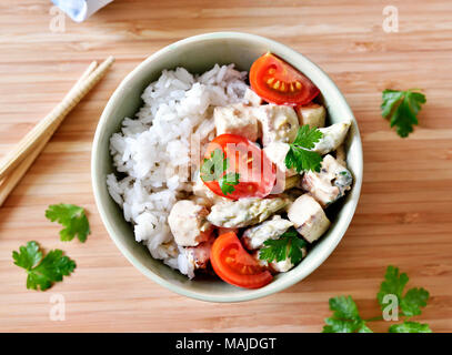 Delicious tofu dish with fresh tomatoes and parsley in a bowl. Rice dish, vegan food or vegetarian meal. Stock Photo