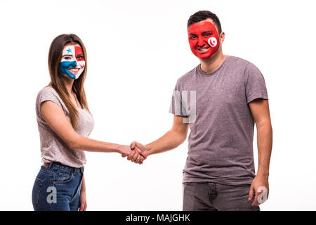 Football fans of Panama and Tunisia national teams with painted face shake hands over white Stock Photo