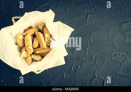 Traditional italian almond cookies cantuccini, overhead view on black stone background with space for text. Homemade biscotti in a white wooden box on Stock Photo