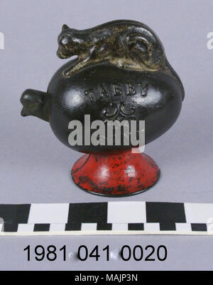 Cast iron bank depicting a cat on top of a hatching egg. Coin slot is on top of the cat's back. When a coin is deposited the hatching chicken's head moves. Title: Tabby Mechanical Coin Bank  . circa 1886. Stock Photo