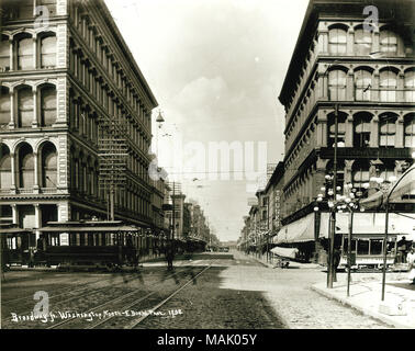 View looking north on Broadway from Washington Avenue. A commercial district including retail stores and the Raboteau and Co. Drugs at 714 North Broadway are visible. Parisian Cloak Company and I.B. Rosenthal Millinery Co. are located at the northeast corner of the intersection. Title: View looking north on Broadway from Washington Avenue.  . 1892. Emil Boehl Stock Photo