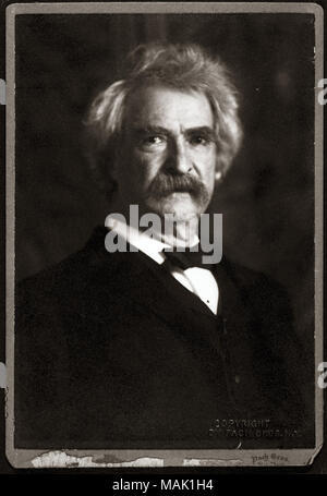 Studio portrait of subject, view from chest up, body facing right, view is straight ahead. This is a cropped print of an original photo showing Twain in a three-quarter body shot seated in the Pach Brothers Studio in New York city. Title: Mark Twain (Samuel Langhorne Clemens).  . 1906. Pach Bros, NY Stock Photo