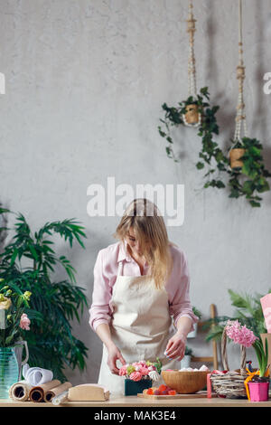 Girl Florist Makes A Bouquet In The Form Of A Nest On A White Table 