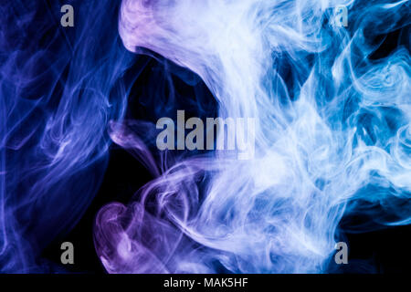 Thick colorful smoke of blue, purple on a black isolated background. Background from the smoke of vape Stock Photo