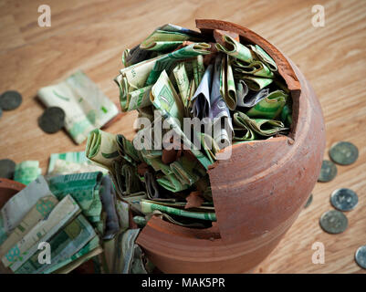 Broken money box, with Saudi Riyal banknotes and coins Stock Photo - Alamy