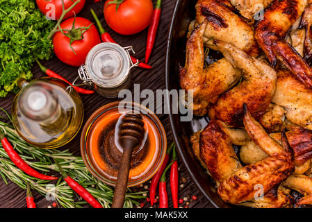 Baked chickens wings covered in honey, vegetables Stock Photo