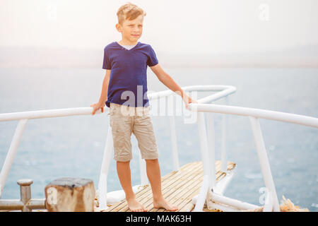 Small boy enjoying summer vacation on sea. Happy boy on yacht cruise. Image with copy space Stock Photo