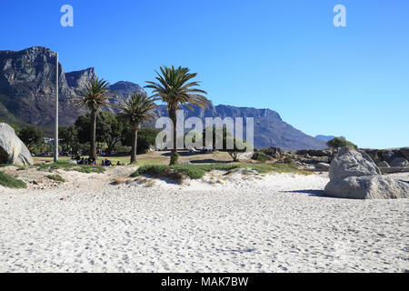 The Twelve Apostles Mountain range beyond the white sands of upmarket Camps Bay, in Cape Town, South Africa Stock Photo