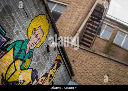 brick walls covered in cartoon graffiti and street art. Stock Photo