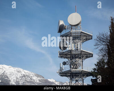 antenna radio among trees and houses in Trentino Stock Photo