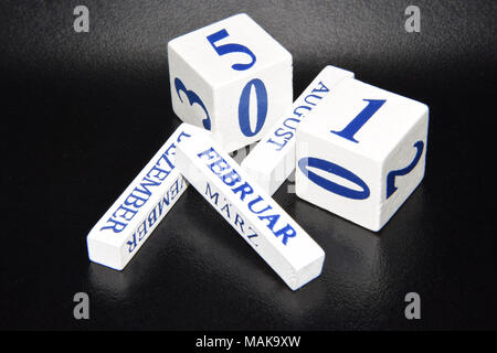 Jumble of White Dice and Wooden Blocks with Letters and Month Names on Them - Calendar Dice, Date Cubes Showing the Months and Days Stock Photo