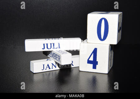 Calendar Dice Showing the Fourth of July Date - White Cubes Reflected in the Black Floor Stock Photo