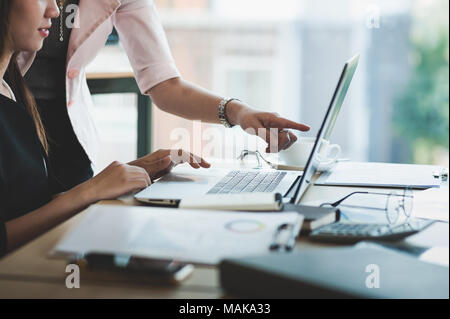 Young Asian business workers working together with laptop computer in office. Business startup teamwork and brainstorm concept Stock Photo