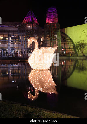 Christmas lights in the shape of a swan at Bluewater, Kent. Christmas lights reflected in a lake at night. Bluewater shopping centre, Kent, UK. Stock Photo