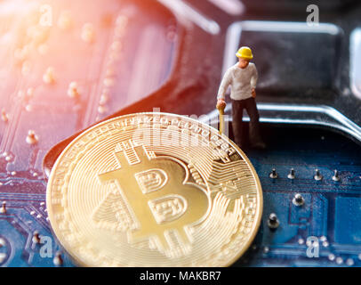 Marco shot of bitcoin and minner worker man , figures working on group of bitcoins. virtual cryptocurrency mining concept Stock Photo