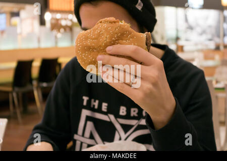 Young man eating burger Stock Photo