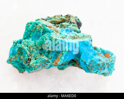 macro shooting of natural mineral rock specimen - Chrysocolla stone in copper sandstone on white marble background from Zabaykalsky Krai of Russia Stock Photo