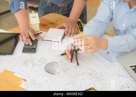 Architect or planner working on drawings for construction plans at a table Stock Photo