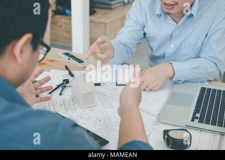 Architect or planner working on drawings for construction plans at a table Stock Photo