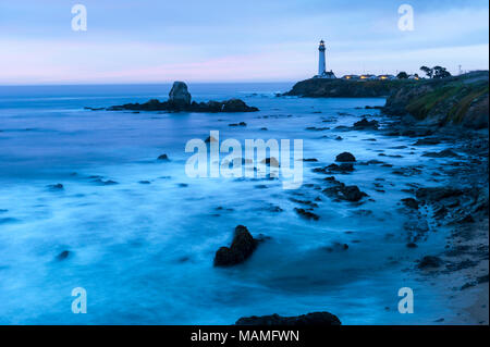 Picturesque historic Pigeon Point Lighthouse, Pescadero, breaking waves on the Pacific Coast of California at dusk, United States of America, USA.
