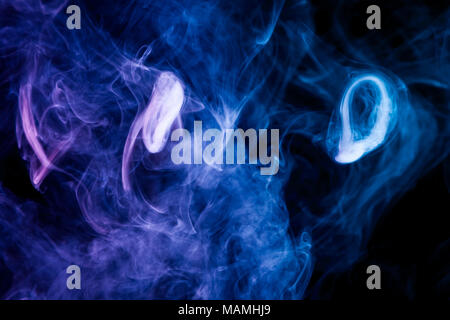 Multi-colored smoke with clubs of blue and purple on a black isolated background Stock Photo