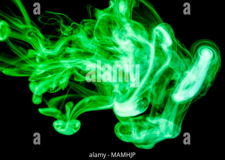 Multi-colored smoke with clubs of green and yellow on a black isolated background Stock Photo