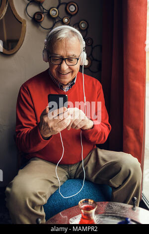 Senior man is sitting in cafe and chatting. Stock Photo