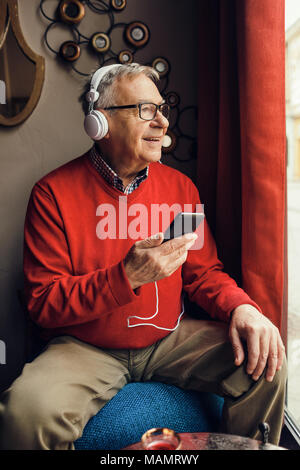 Senior man is sitting in cafe and chatting. Stock Photo