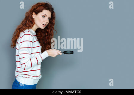 Smart young woman using magnifying glass Stock Photo