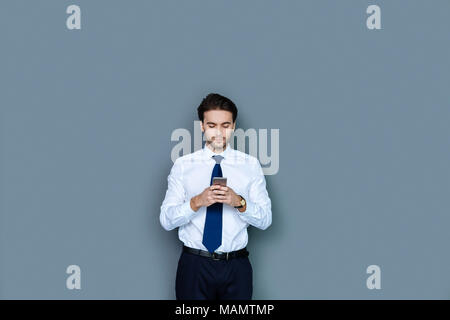 Smart nice businessman using his smartphone Stock Photo