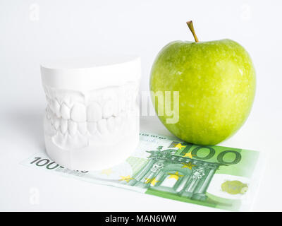 The green apple, the denture and the one hundred euro bill Stock Photo