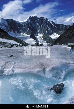 Water stream in snow, stone. Arbuz glacier, Altai mountains, Russia Stock Photo