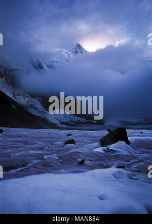 Mountain top among clouds in sunset. Arbuz glacier, Altai, Russia Stock Photo