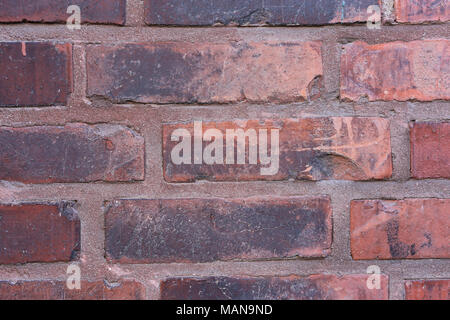 Red and black exterior wall made with red tilas that have turned orange and black over time. Beautiful rustic texture. Stock Photo