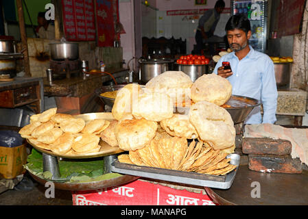 Street vendor in an Indian town prepares food for his customers. Stock Photo