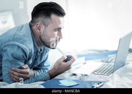Serious smart man holding a pen Stock Photo