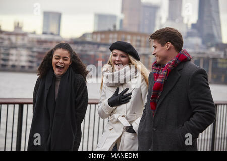 Friends Walking Along South Bank On Winter Visit To London Stock Photo
