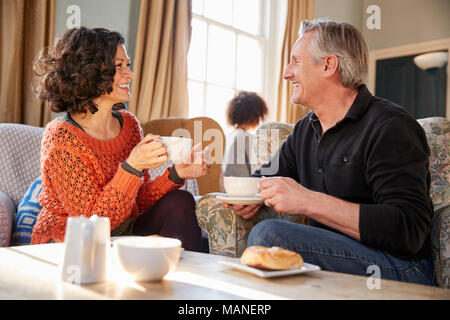 Middle Aged Couple Sitting Around Table In Coffee Shop Stock Photo