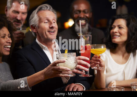 Group Of Middle Aged Friends Celebrating In Bar Together Stock Photo