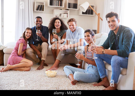 Portrait Of Friends Relaxing At Home And Drinking Wine Together Stock Photo