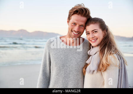 Portrait Of Loving Couple Walking Along Winter Beach Together Stock Photo