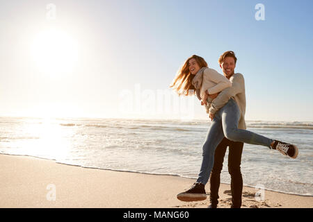 Couple Having Fun On Winter Beach Together Stock Photo