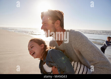 Father With Daughter Having Fun On Winter Beach Together