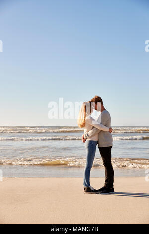 Romantic Couple Embracing On Winter Beach Stock Photo