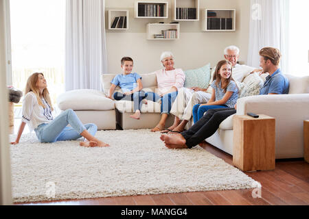 Multi Generation Family Relaxing On Sofa At Home Together Stock Photo