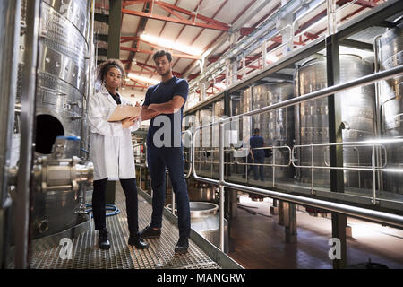Male and female wine factory technicians looking to camera Stock Photo